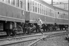 849711 Afbeelding van de controle van de wielen van een internationale trein op het emplacement Dijksgracht van de N.S. ...